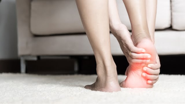 Persona con dolor en el talón al despertar por la mañana, síntoma típico de fascitis plantar